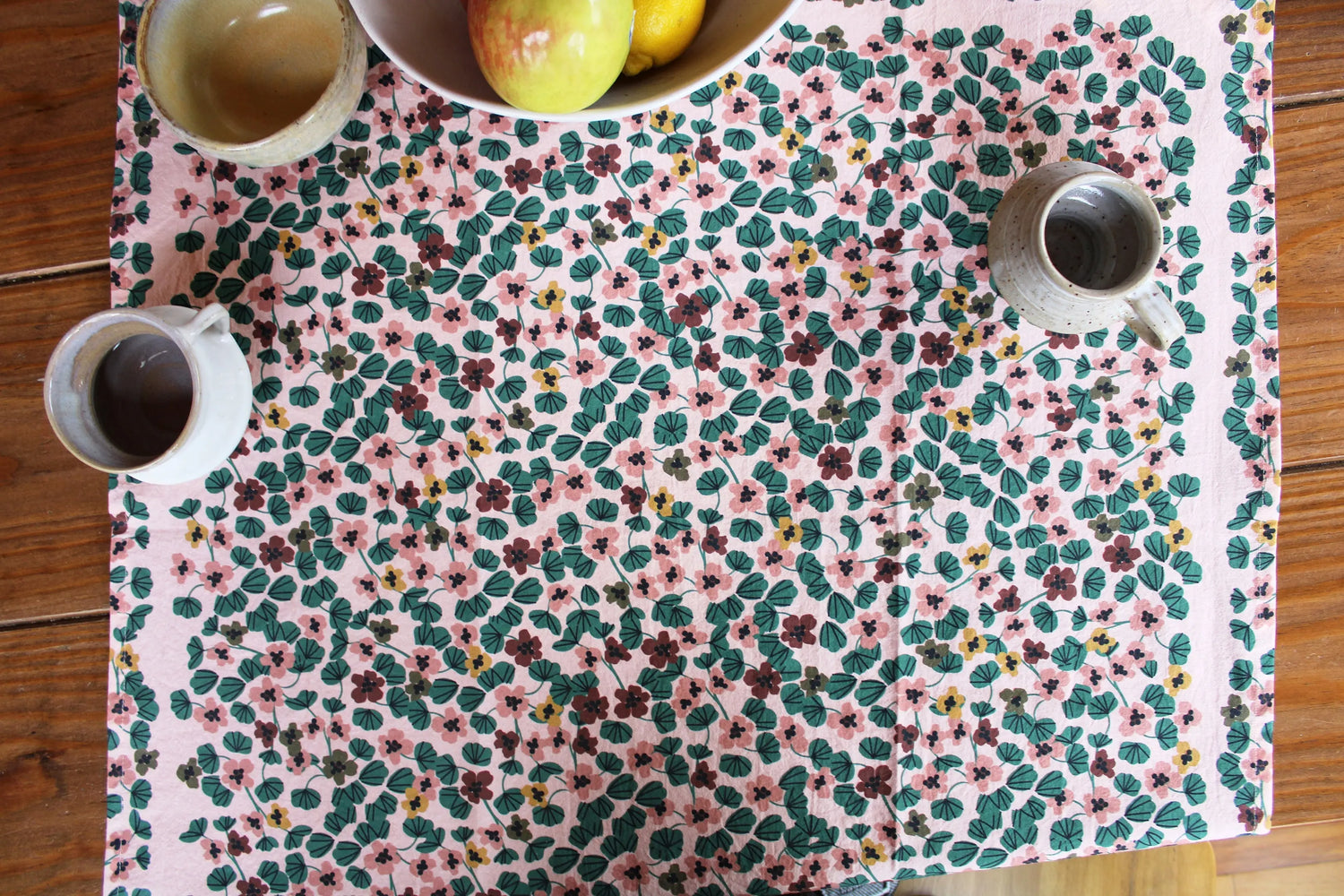 table with floral nasturtium tea towel and pottery