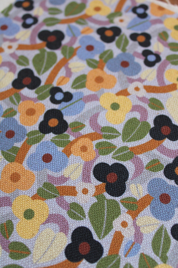 Floral patterned fabric with colorful flowers and leaves on a blue background
