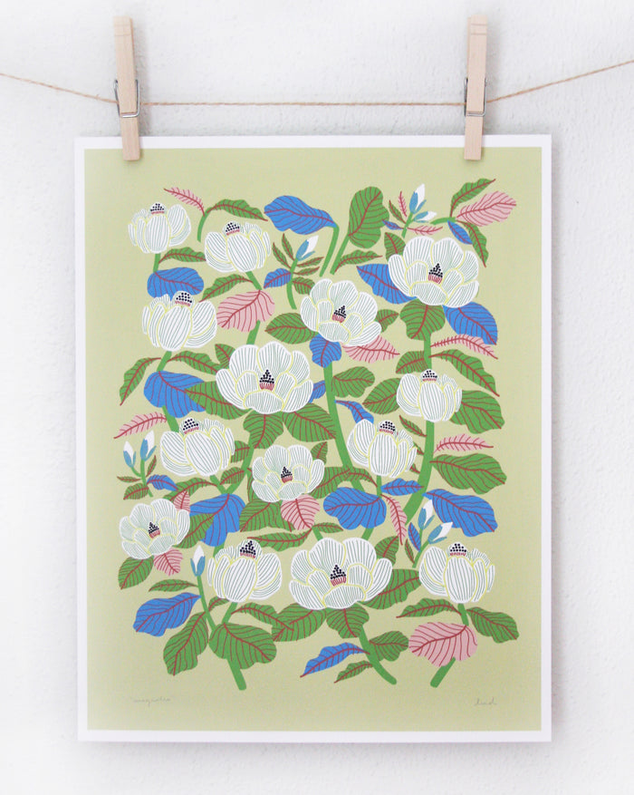 Magnolia print in chartreuse with white flowers and multicolored leaves on acid-free artisan paper hanging on a line
